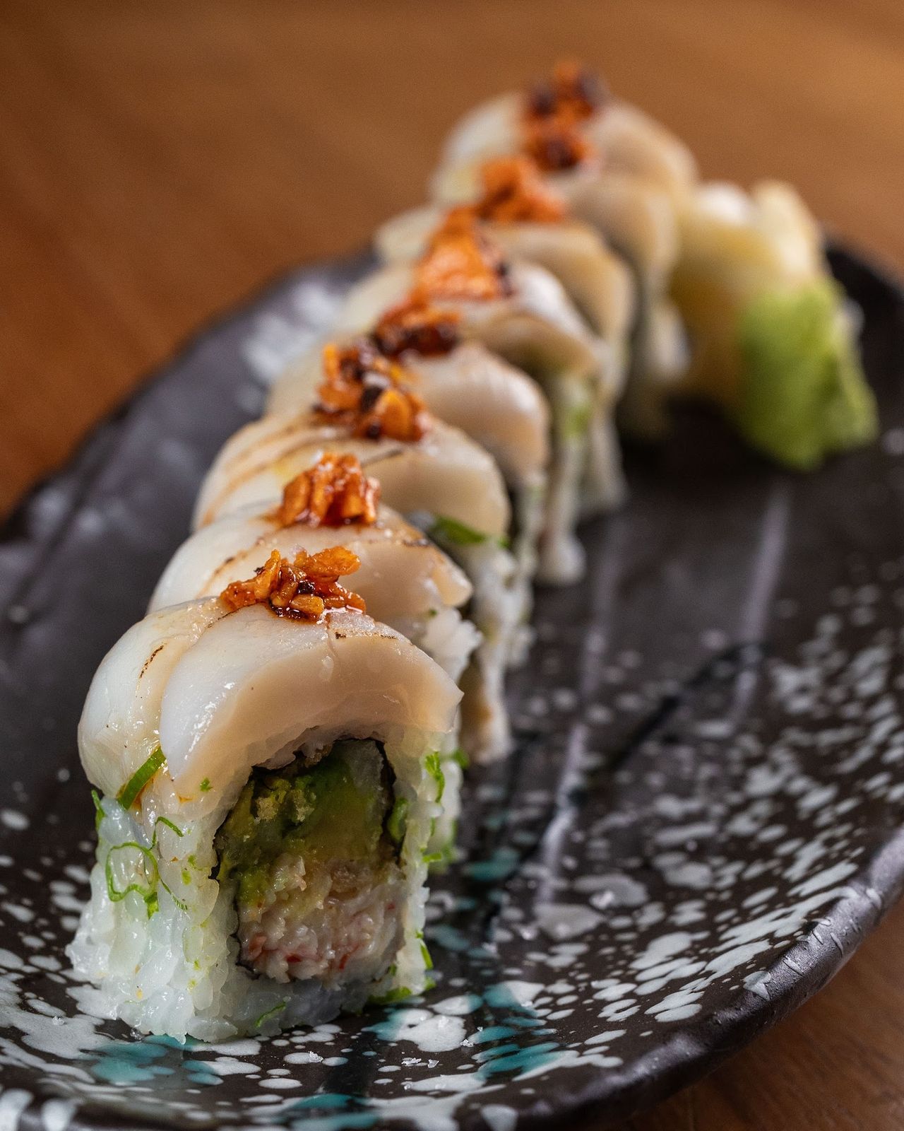 99 Sushi Bar Dubai interior &mdash; warm wood counter, dim recessed lighting, omakase chef stations