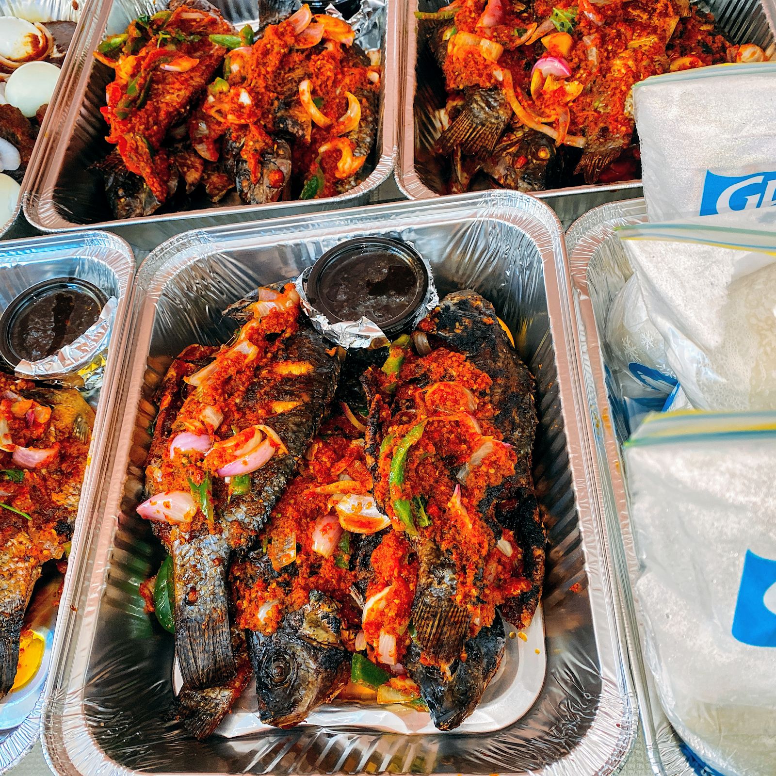 Ghanaian food spread — grilled tilapia, plantain, rice