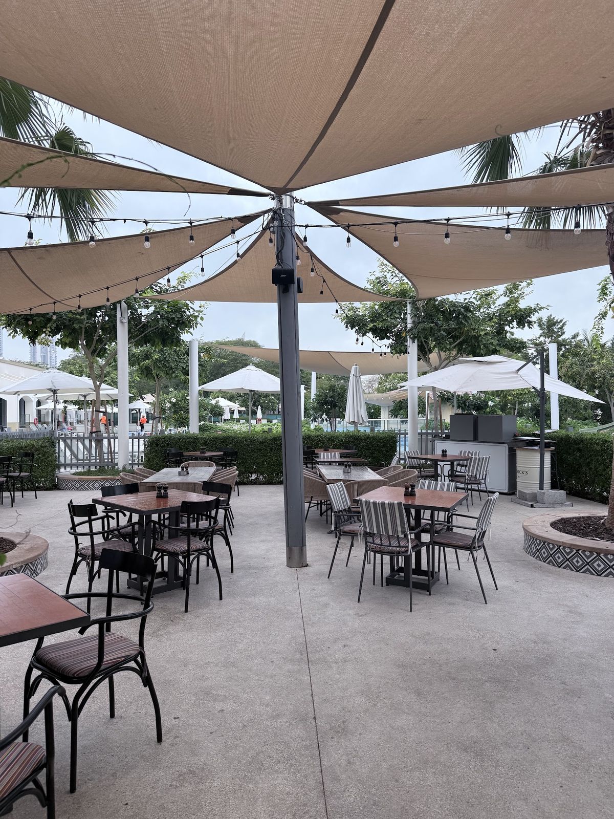 Reform Social & Grill Dubai — garden terrace seating at The Lakes
