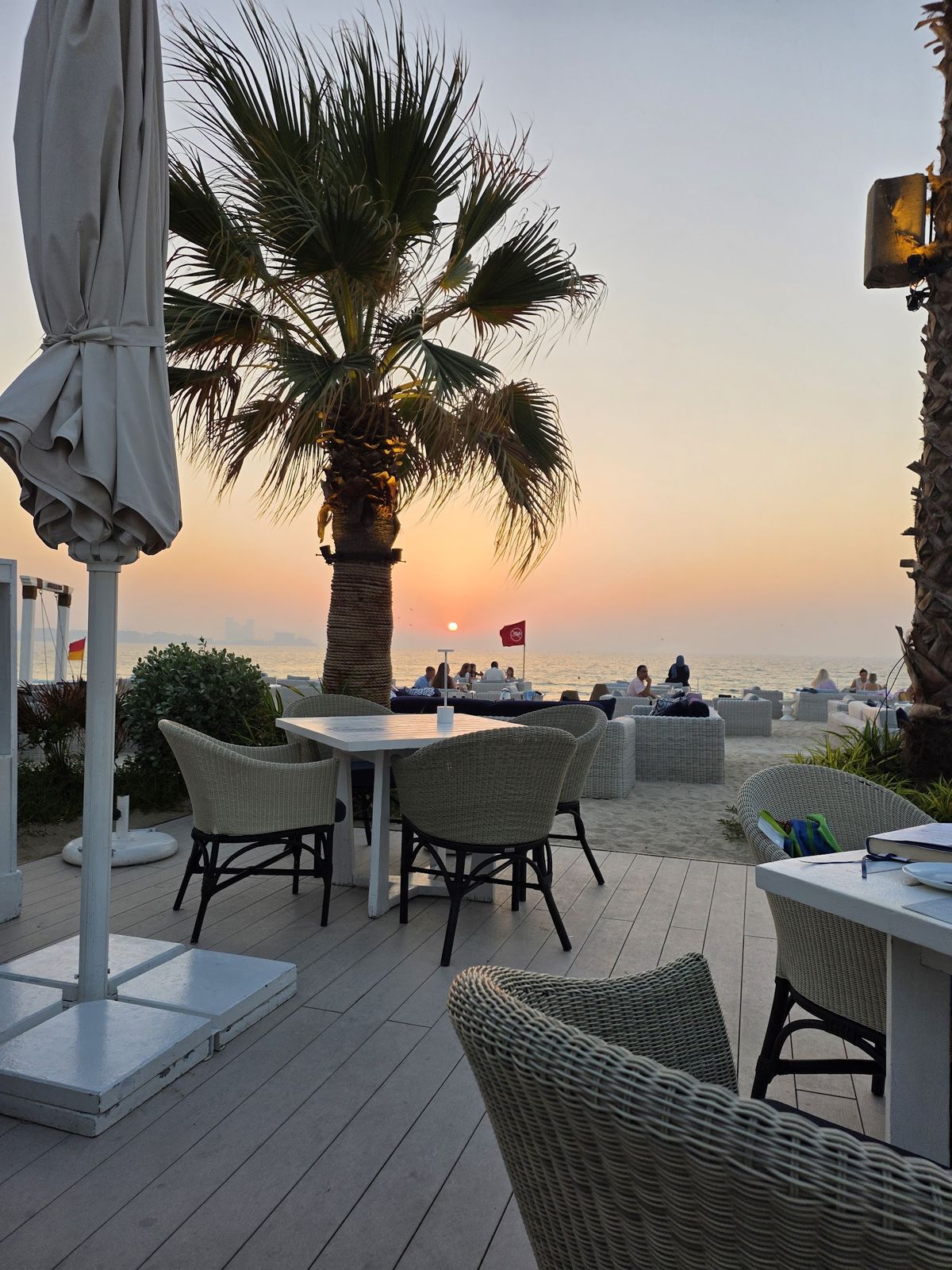 Shimmers Dubai — beachfront Greek taverna tables on the sand at Mina A'Salam with Burj Al Arab view