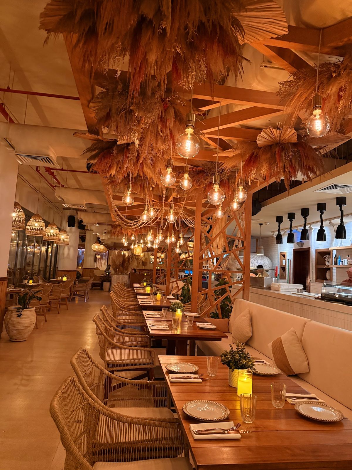 Ula Dubai — boho beach house dining on Palm West Beach at sunset