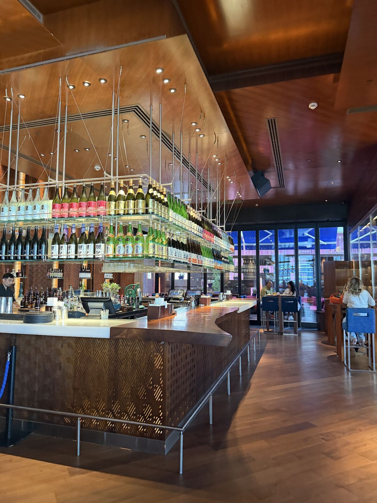 Zuma Dubai DIFC dining room — central bar, warm wood, open kitchen
